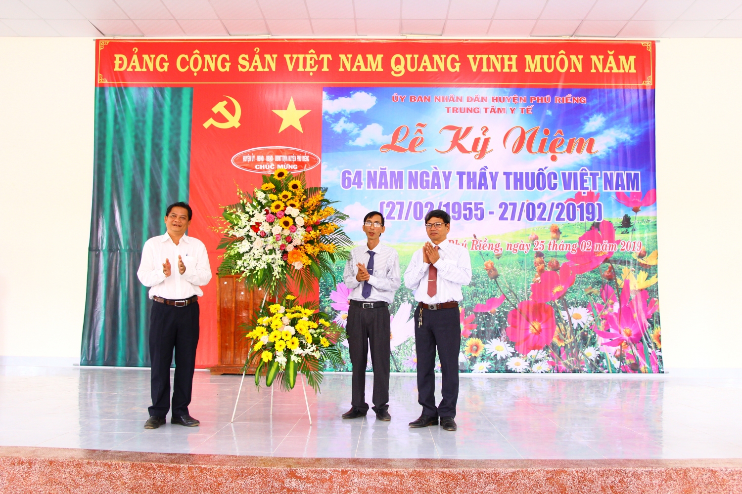 Phó Bí thư Thường trực Huyện ủy Bùi Quốc Minh tặng lẵng hoa chúc mừng của huyện Phú Riềng cho trung tâm y tế huyện.