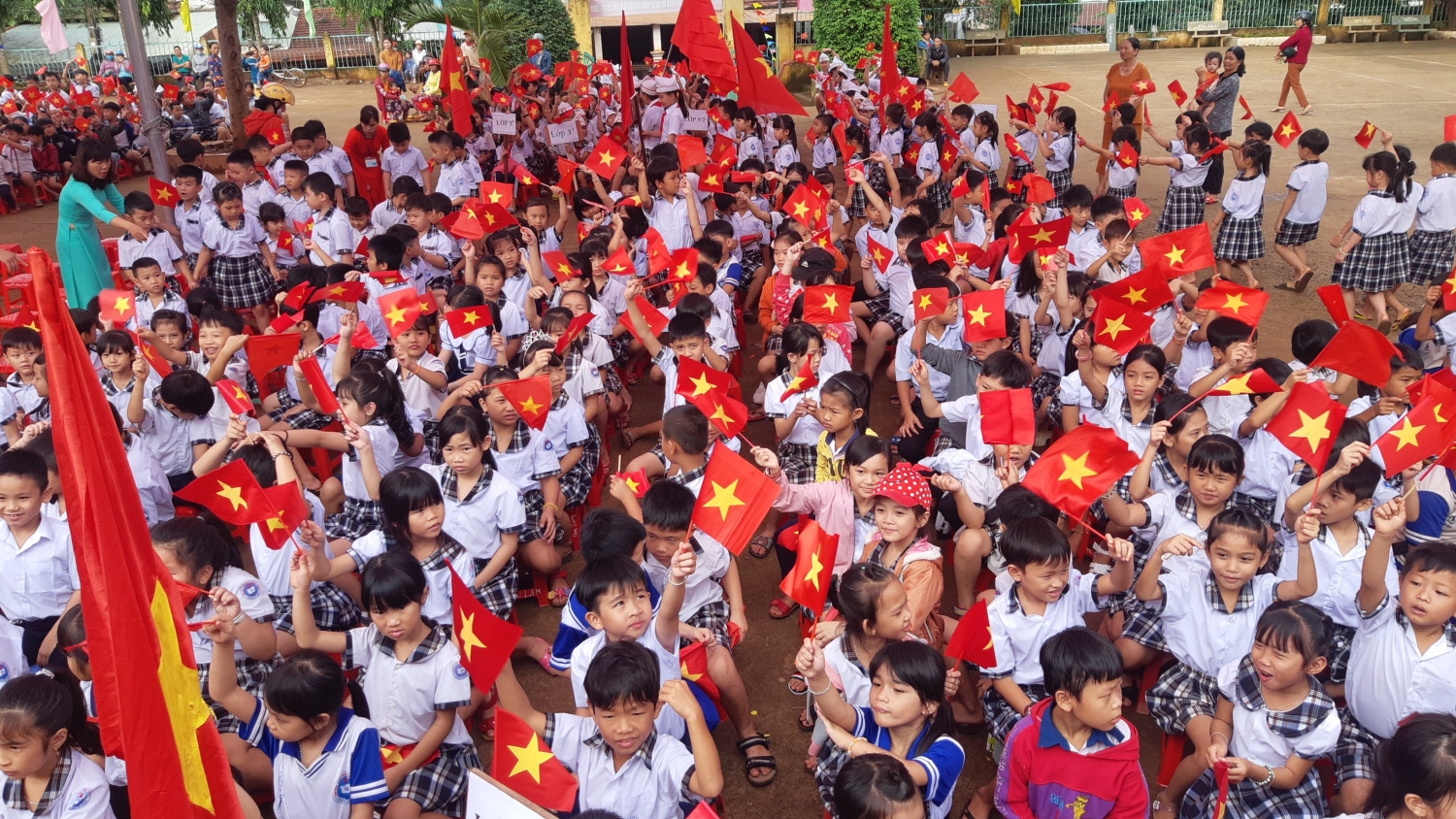 Các em học sinh vẩy cờ chào đón các em học sinh lớp 1 tại trường tiểu học Nghĩa Trung, xã Nghĩa Trung (Bù Đăng)