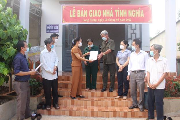 Bà Doãn Thị Mai Xuân, Phó phòng Nội vụ- Lao động Thương binh và Xã Hội trao quyết định tặng nhà cho gia đình ông Cao Trọng Hoạt.