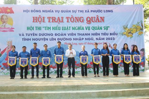 Ông Nguyễn Ngọc Công Phó bí thư, chủ tịch UBND, chủ tịch Hội đồng NVQS thị xã Phước Long trao cờ lưu niệm cho các cơ sở Đoàn tham gia Hội trại